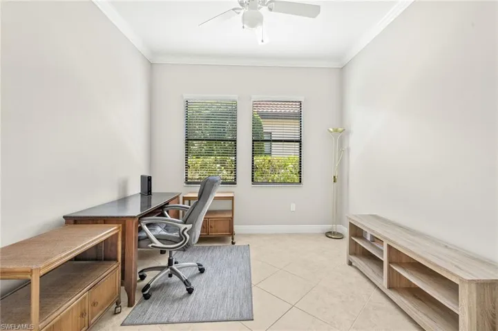 Office space featuring baseboards, a ceiling fan, crown molding, and light tile patterned floors