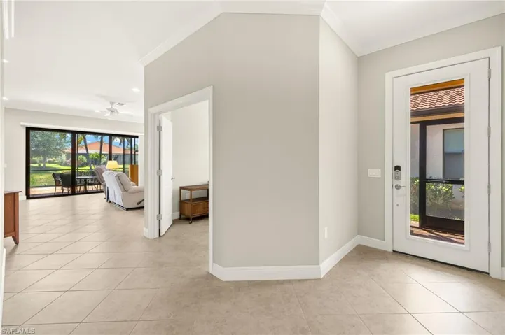 Foyer entrance featuring baseboards, recessed lighting, crown molding, and light tile patterned floors