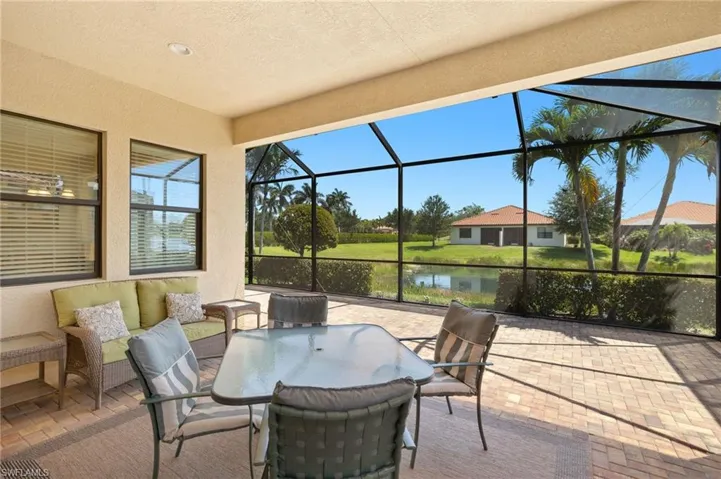 View of patio featuring a lanai and a water view