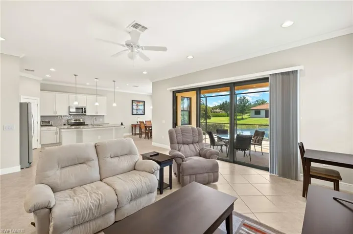 Living area featuring light tile patterned floors, ceiling fan, baseboards, visible vents, and recessed lighting