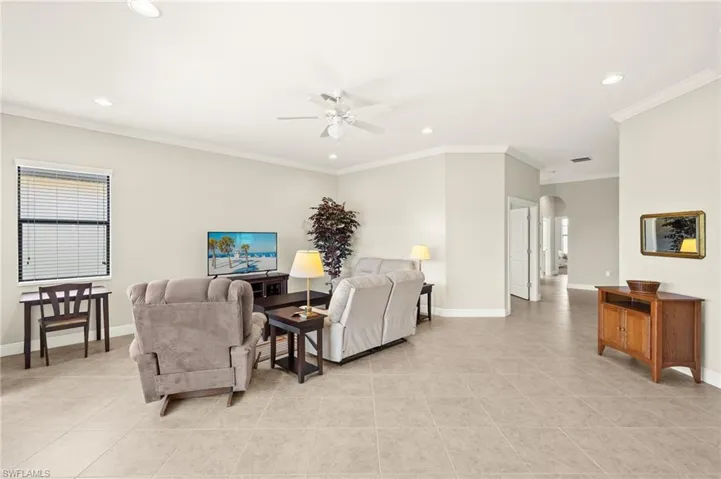 Living room featuring arched walkways, a ceiling fan, baseboards, and recessed lighting