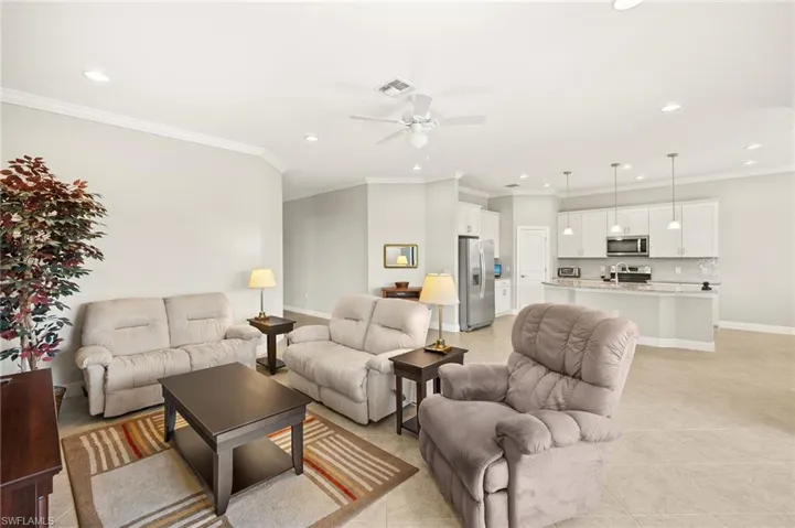 Living room with ceiling fan, ornamental molding, visible vents, and recessed lighting
