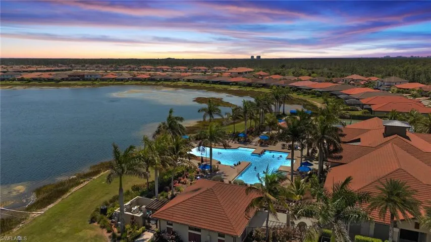 Aerial view at dusk featuring a water view and a residential view