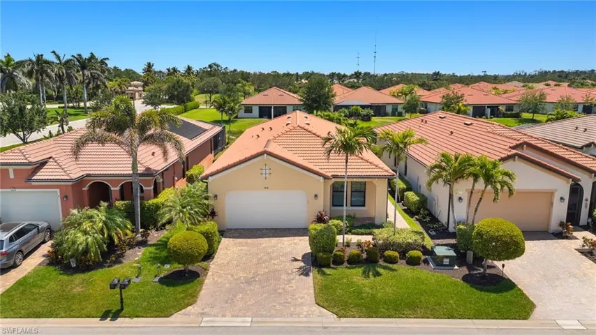 Mediterranean / spanish-style home with stucco siding, a tile roof, a residential view, and decorative driveway