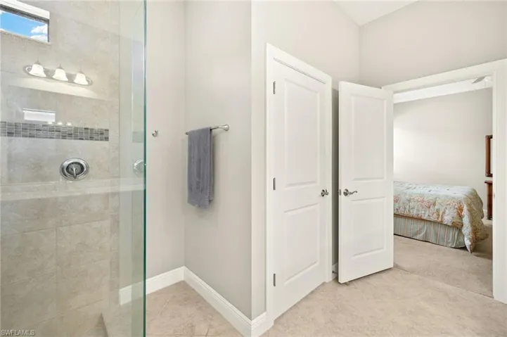 Ensuite bathroom with tile patterned floors, ensuite bathroom, baseboards, and a tile shower