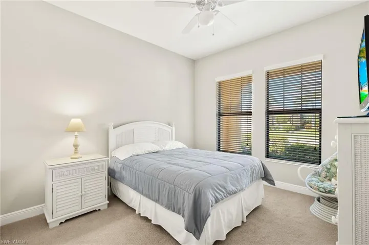 Bedroom featuring ceiling fan, baseboards, and light colored carpet
