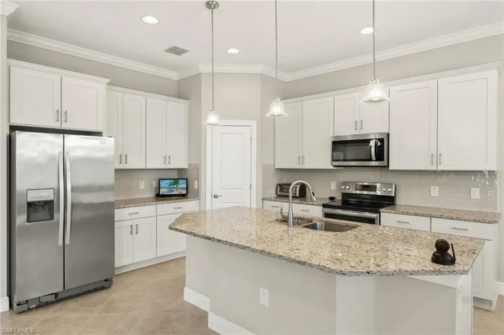Kitchen featuring visible vents, a sink, decorative backsplash, appliances with stainless steel finishes, and white cabinetry