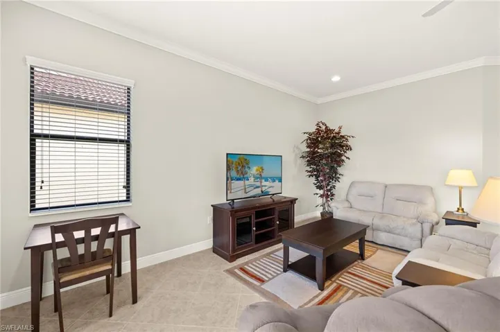 Living room with recessed lighting, baseboards, ornamental molding, and light tile patterned floors
