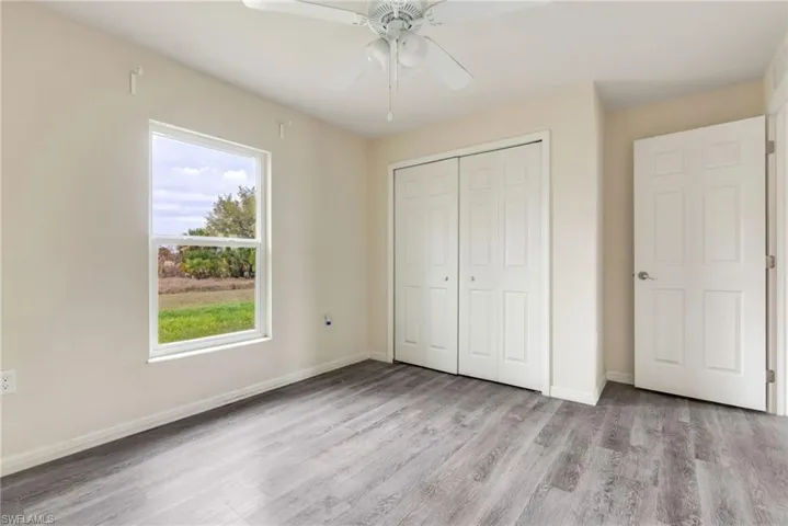 Unfurnished bedroom featuring light wood-type flooring, a ceiling fan, and a closet