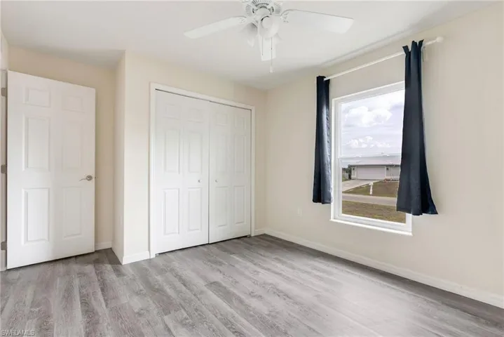 Unfurnished bedroom featuring light wood finished floors, a closet, and ceiling fan