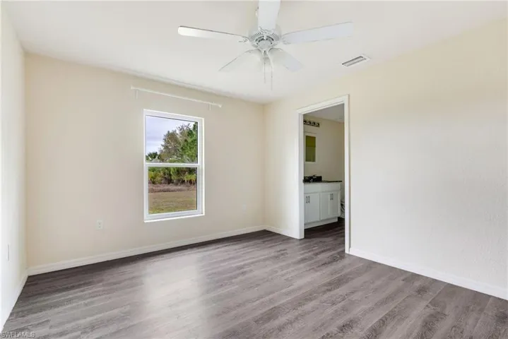 Empty room with light wood-style floors and ceiling fan