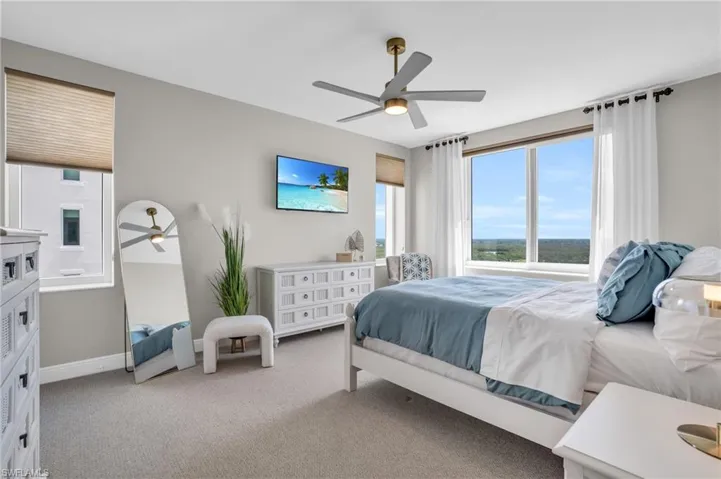 Carpeted bedroom featuring ceiling fan