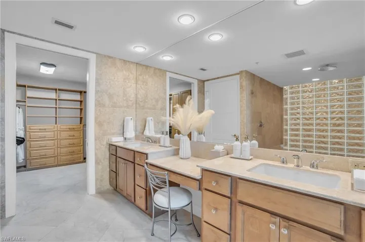 Bathroom with tile flooring, tile walls, and vanity