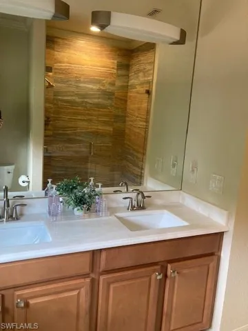Bathroom with double sink vanity and toilet