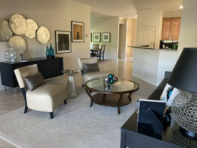 Tiled living room featuring sink and ornamental molding