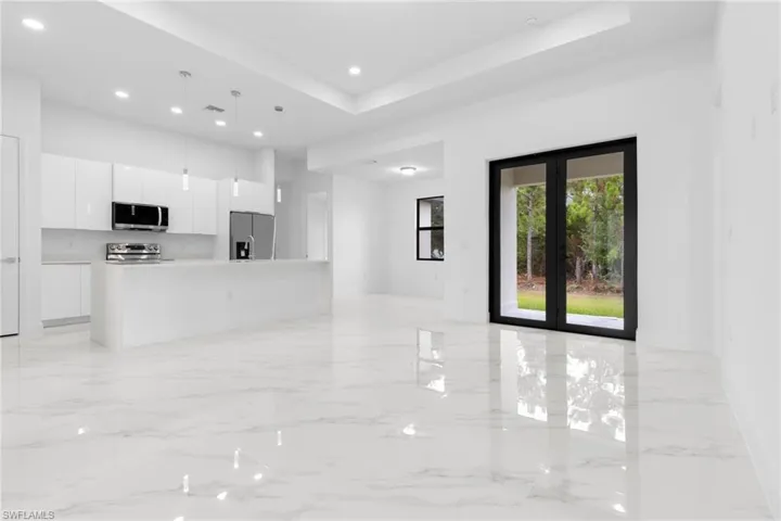 Kitchen with a center island, white cabinetry, french doors, stainless steel appliances, and a raised ceiling