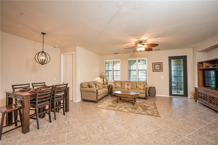 Living room with a textured ceiling, a ceiling fan, and a chandelier