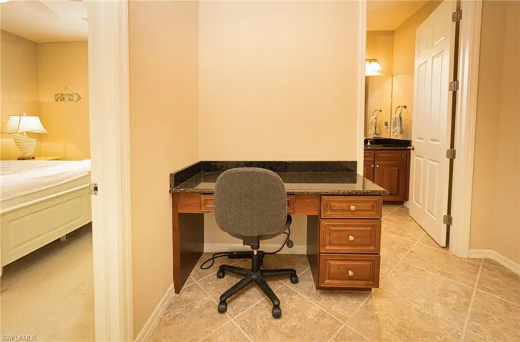 Office featuring built in desk and light tile patterned floors
