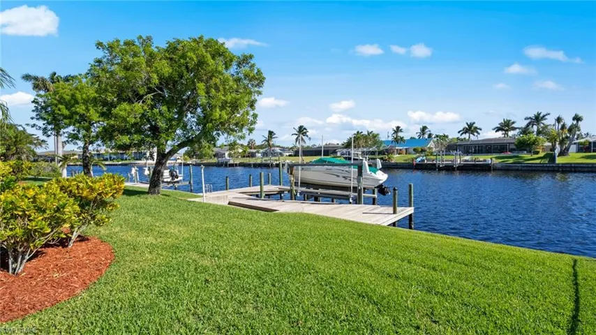 View of dock with a water view and a yard