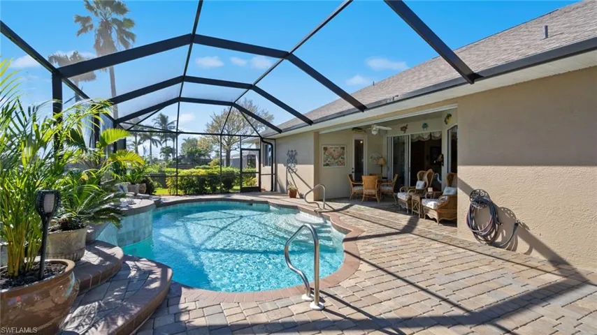 View of swimming pool with a patio, ceiling fan, and a lanai