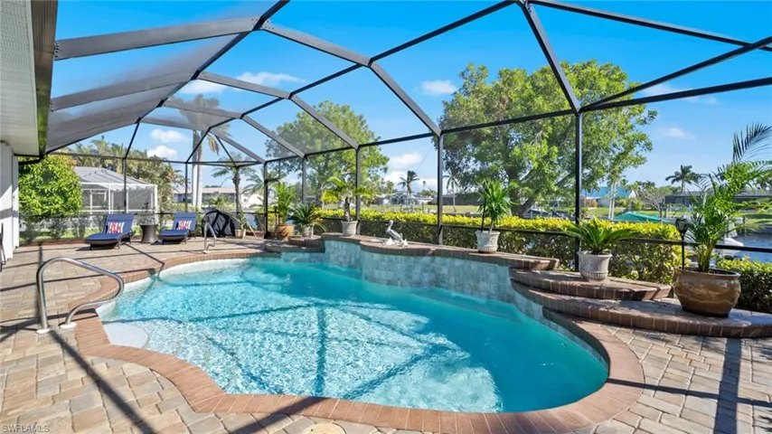 View of swimming pool featuring glass enclosure and a patio area