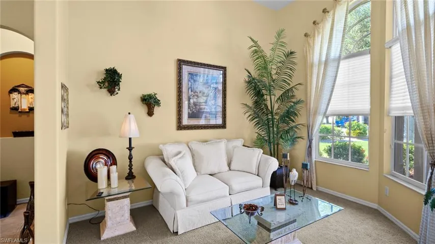 Living room with carpet flooring and a healthy amount of sunlight