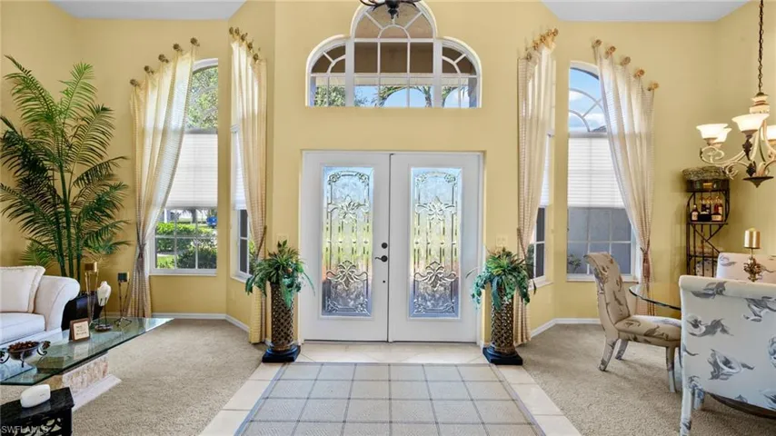 Foyer with french doors, light colored carpet, and a wealth of natural light