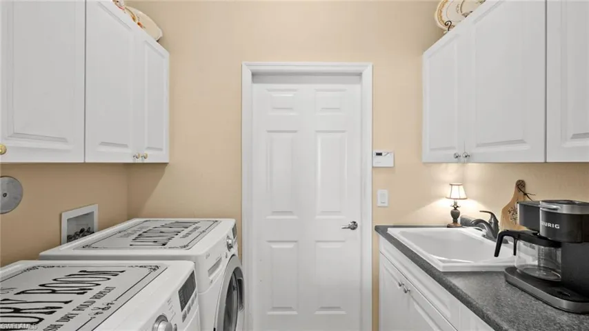 Laundry area with cabinets, sink, and washing machine and dryer