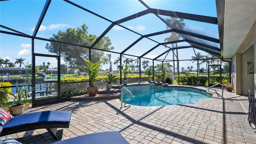 View of swimming pool featuring glass enclosure and a patio area