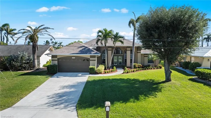 Ranch-style home with a front lawn and a garage