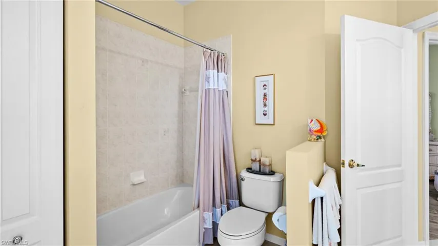 Bathroom featuring shower / tub combo and toilet