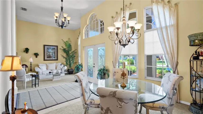 Carpeted dining room featuring a wealth of natural light and a chandelier