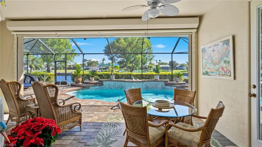 View of swimming pool featuring ceiling fan and a water view