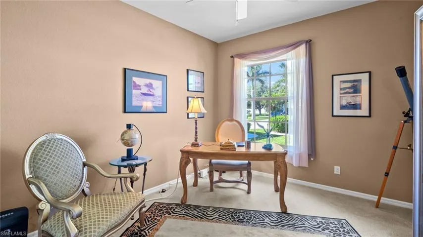 Home office featuring light carpet and ceiling fan