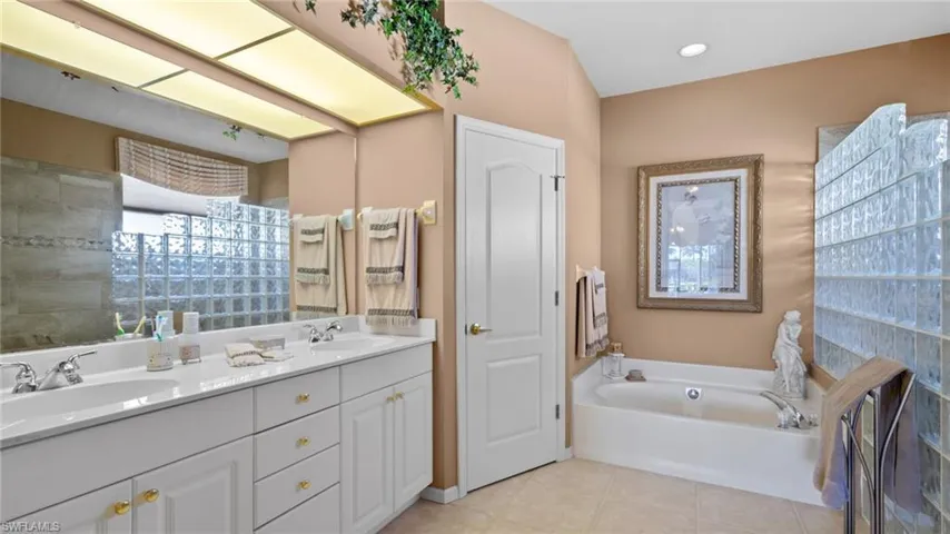 Bathroom with a bath, vanity, and tile patterned floors