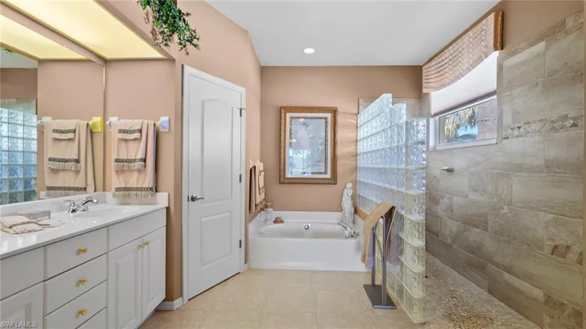 Bathroom with shower with separate bathtub, vanity, and tile patterned floors
