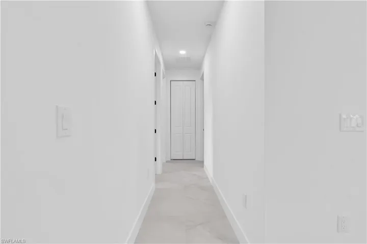 Corridor featuring recessed lighting and light marble finish floors