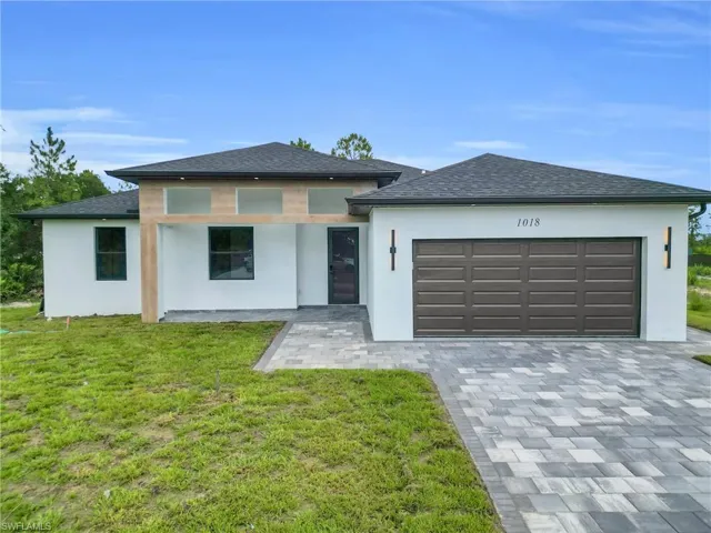 Prairie-style home featuring decorative driveway and stucco siding