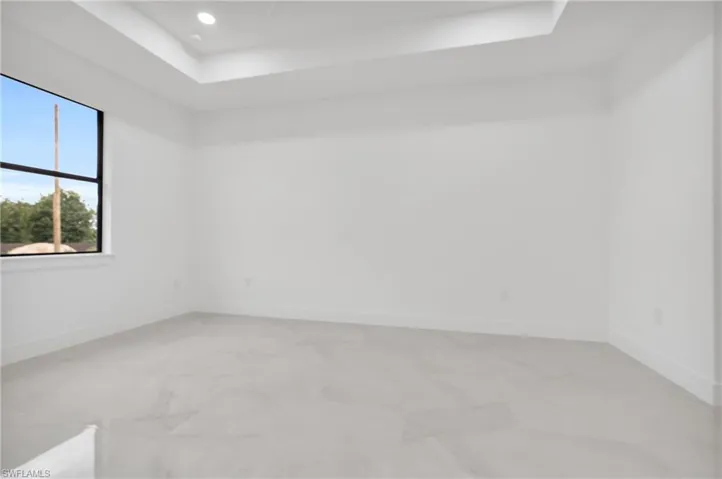 Spare room featuring a raised ceiling and recessed lighting