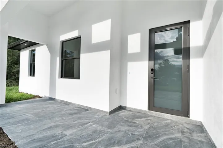 Property entrance with stucco siding and a patio area