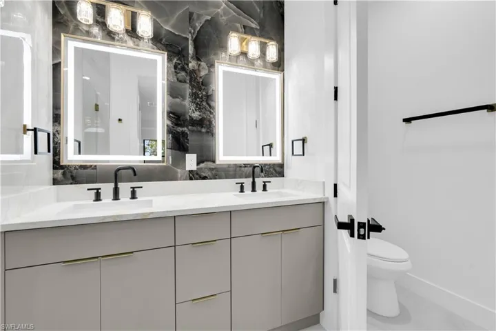 Bathroom featuring double vanity and toilet