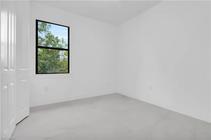 Spare room with concrete flooring and baseboards