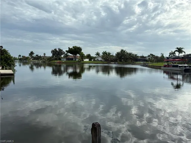 Expansive waterfront with a wooden dock and mature tropical landscaping
