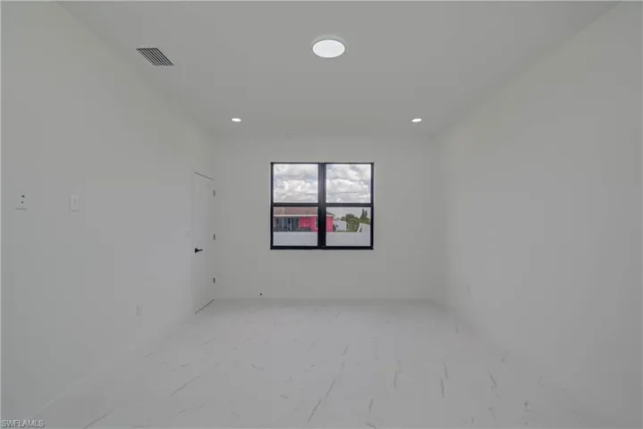 Unfurnished room with light marble finish floors and recessed lighting