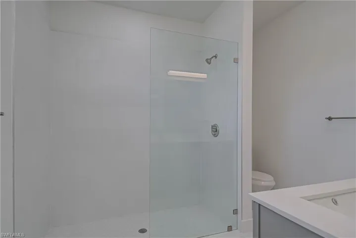 Full bath featuring vanity and tiled shower