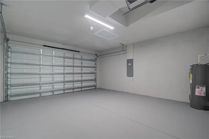 Garage featuring water heater and electric panel