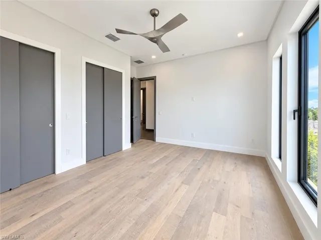 Light wood-finish flooring, recessed lighting, and a modern ceiling fan