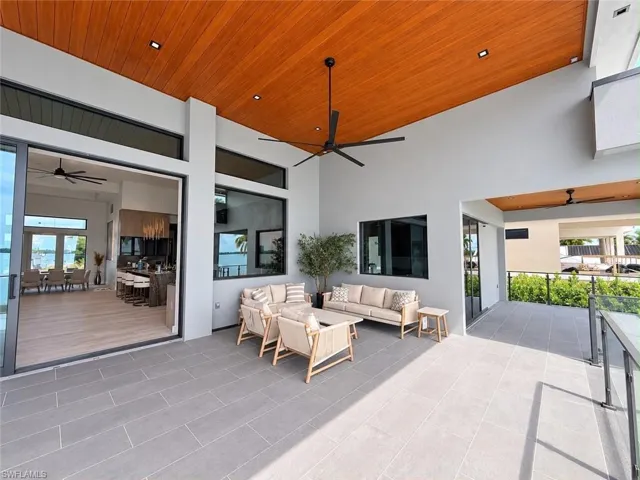 Expansive covered patio with plank tile flooring, wood-finish ceiling, recessed lighting, and a ceiling fan