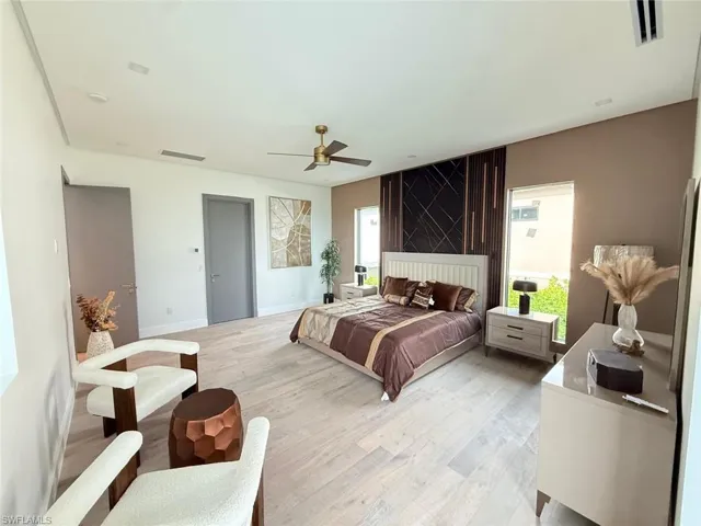 Light wood-finish flooring, recessed lighting, and a ceiling fan with integrated light