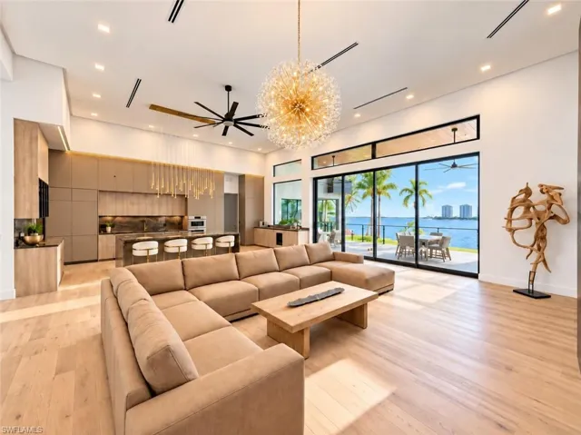 Expansive wood-finish flooring throughout, complemented by a contemporary kitchen featuring integrated appliances and a spacious island